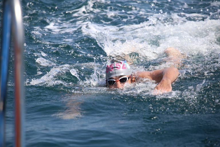 Triathlete swimming with eyes above the water in open water